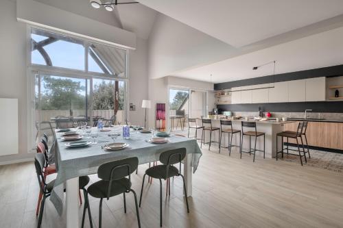 une salle à manger et une cuisine avec une table et des chaises dans l'établissement Triplex pour 12 - 400m de la plage des Libraires, à Pornichet