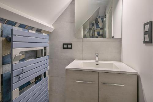 a bathroom with a sink and a mirror at Viree en famille a Pornichet in Pornichet