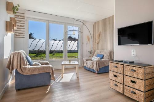 a living room with a tv and a couch and a chair at Appartement pour 4 avec grand jardin in Préfailles