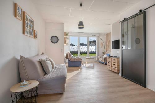 a living room with a couch and a table at Appartement pour 4 avec grand jardin in Préfailles