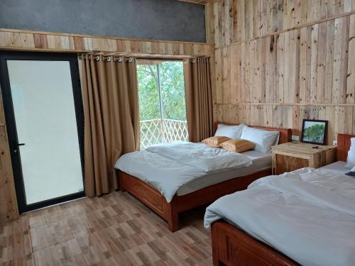 a bedroom with two beds and a window at Hill House in Mai Chau