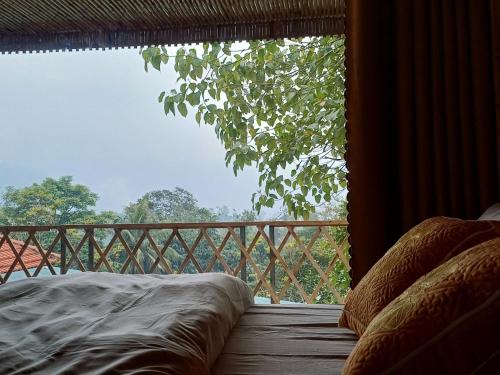 a balcony with a bed and a large window at Hill House in Mai Chau