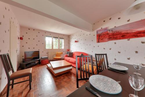 un salon avec un canapé rouge et une table dans l'établissement Séjour pour 4 à Sarzeau, à Sarzeau