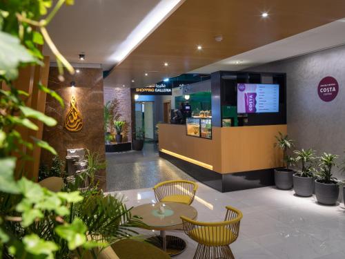 a restaurant with chairs and tables in a lobby at Al Khoory Executive Hotel, Al Wasl in Dubai