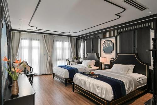 a large bedroom with two beds and a table at Thiên Ân Boutique Hotel in Bạc Liêu