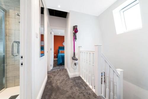 a bathroom with a walk in shower next to a hallway at Stunning Double Rooms within a Loft space in London