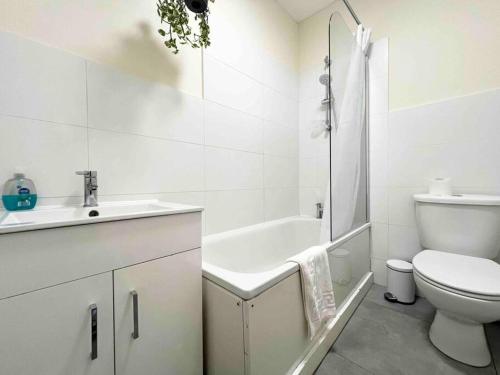 a white bathroom with a sink and a toilet at 4 Bed Apartment- Archway Station in London