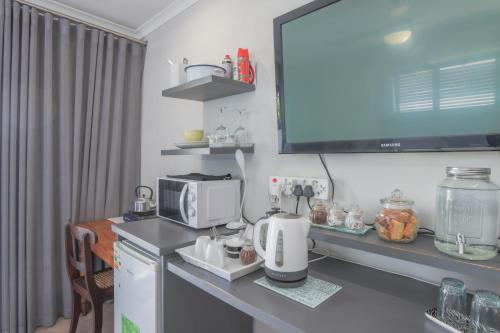 a kitchen with a counter with a coffee maker and a microwave at Lily's Rest, Village on Silwerstrand, Robertson in Robertson