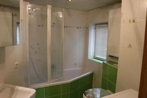 een badkamer met een douche en een bad bij XXL Ferienliebe in Habrachćicy