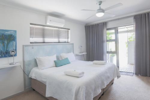 a bedroom with a large bed with two towels on it at Lily's Rest, Village on Silwerstrand, Robertson in Robertson