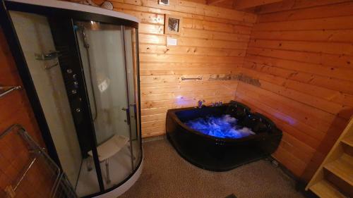ein Bad mit einer schwarzen Badewanne und einer Dusche in der Unterkunft Chalet Ermelo in Ermelo