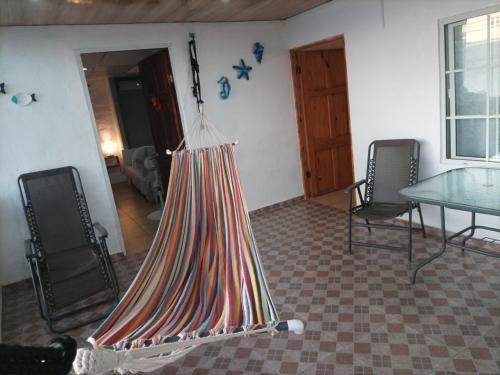 um quarto com uma mesa e cadeiras e uma tenda suspensa em La casa de Wili Taboga 62,61,00,07 em Taboga