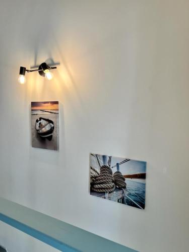 three photographs hanging on a wall with a light at Le Palantin in Le Palais