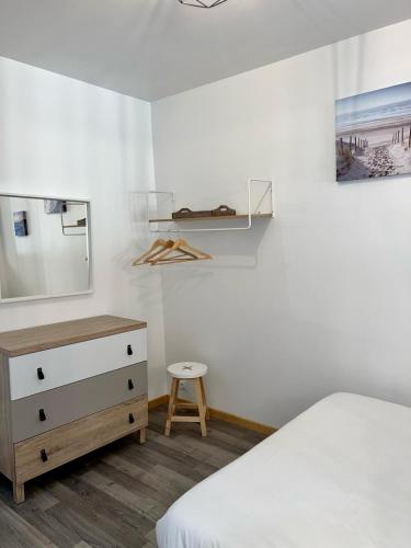 a bedroom with a bed and a dresser and a mirror at Le Palantin in Le Palais