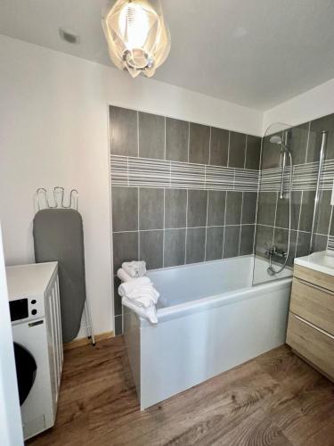 a bathroom with a tub and a sink at Le Palantin in Le Palais