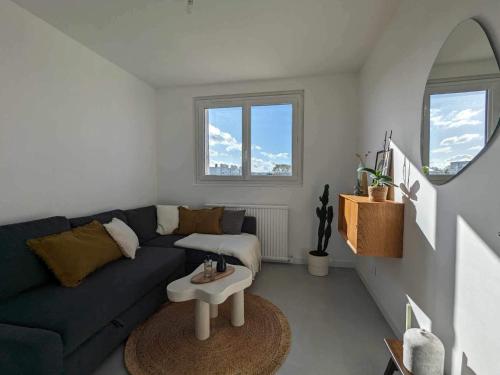 un salon avec un canapé bleu et une table dans l'établissement Appartement refait à neuf, à Alfortville