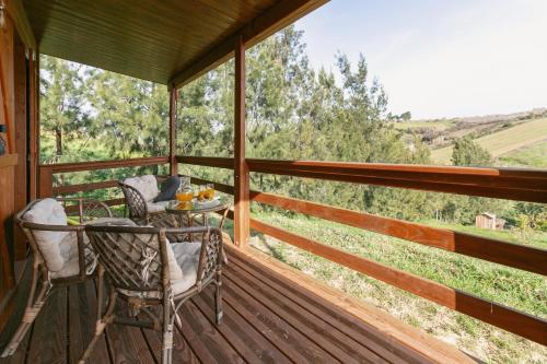 a porch with a table and chairs and a view of the countryside at Quinta dos Castanheiros in Usseira