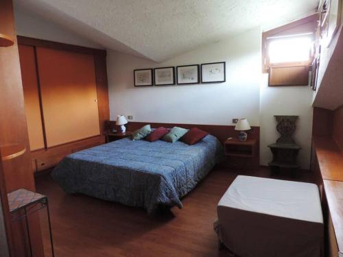 1 Schlafzimmer mit einem blauen Bett und 2 Tischen in der Unterkunft Appartamento per 6 nel Residence La Ginestra in Pescasseroli