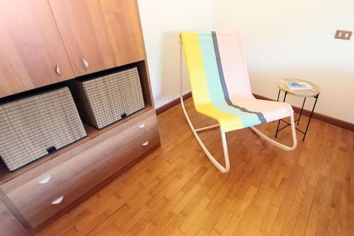 a yellow chair sitting in a room next to a cabinet at Bella vista lago e parcheggio privato - Acquaseria centro in Acquaseria