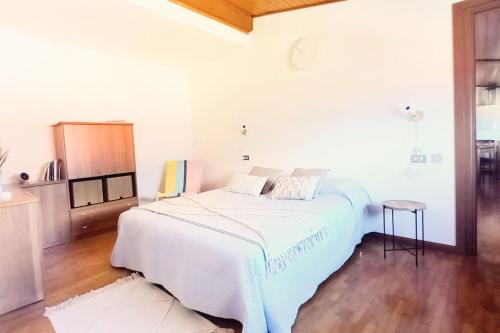 Un dormitorio blanco con una cama grande y una mesa en Appartamento in centro con vista lago a 5 minuti da Menaggio, en Acquaseria