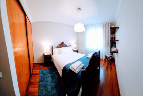 ein Schlafzimmer mit einem weißen Bett und einem blauen Teppich in der Unterkunft Casa da Senra in Vila do Conde