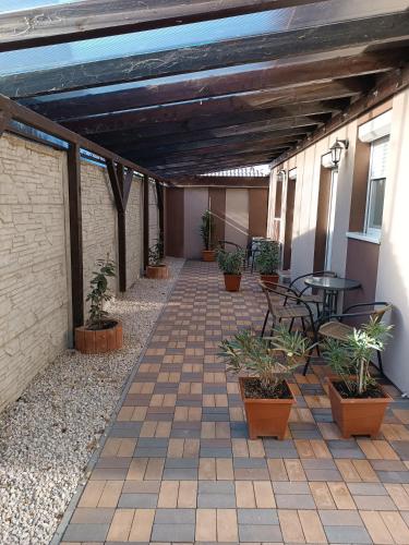 a patio with potted plants and a table and chairs at Boglárka Vendégház in Mosonmagyaróvár