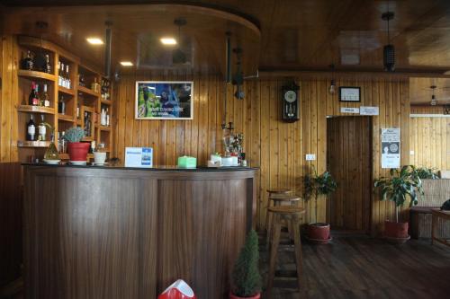 a bar in a restaurant with wooden walls at East On Blue Hotel in Ilām