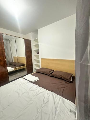 um quarto com uma cama grande e um espelho em Sweat Home em Sevran