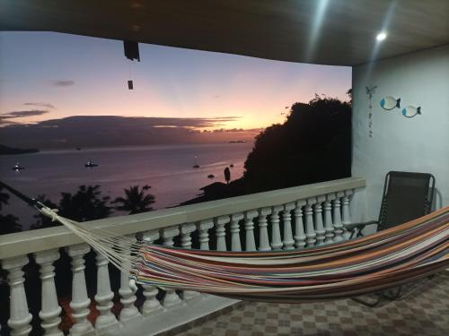 a hammock on a balcony with a view of the ocean at La casa de Wili Taboga 62,61,00,07 in Taboga