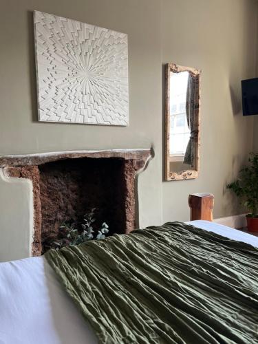 um quarto com uma cama grande e uma lareira em The Roost em Cullompton