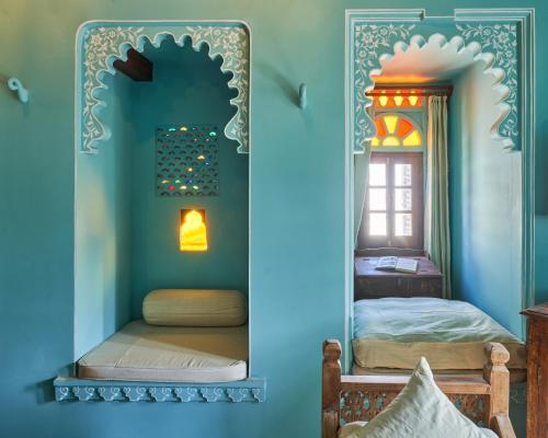 a room with two beds and a mirror at Kaladwas Lal Haveli - A Heritage Boutique Hotel in Udaipur