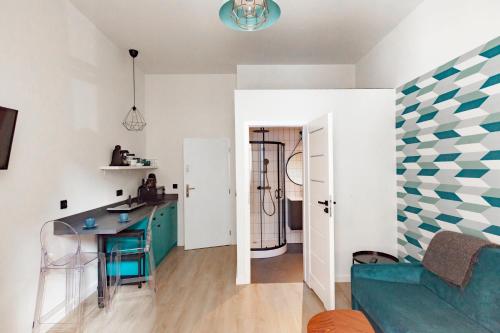 Una cocina y una sala de estar con un sofá azul. en Cracow city heart - 19th-century tenement house of Stanislaw Wyspianski, en Cracovia