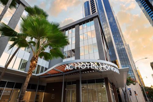 a building with a palm tree in front of it at AC Hotel by Marriott Honolulu in Honolulu