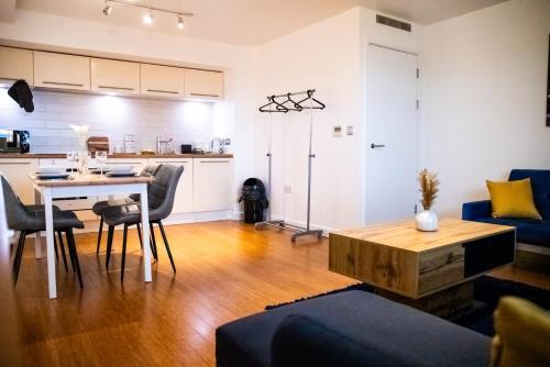 a living room with a table and a kitchen at Close To Leeds City, Spacious, Sleeps 4, in Beeston Hill
