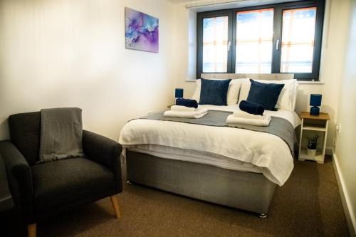 a bedroom with a bed with a chair and a window at Close To Leeds City, Spacious, Sleeps 4, in Beeston Hill