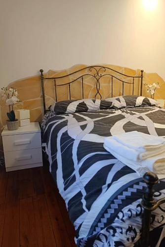1 cama con manta blanca y negra y mesita de noche en Il Rifugio di Piazza dell' Oca, en Ronciglione