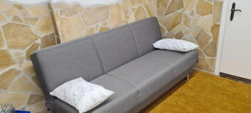 a gray couch with two pillows on top of it at Il Rifugio di Piazza dell' Oca in Ronciglione