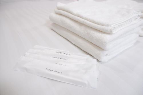 una pila de toallas blancas en una mesa blanca en GLOU Minami Koiwa, en Tokio