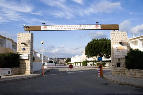 a gate in a street with a street sign at Os Apartamentos A Ramos na Praia da Galé Estão inserido em Condomínio com PISCINA, Fica apenas a 350 Metros da Praia da Galé - Apartamentos com Ar Condicionado tanto nos Quartos como na Sala, Smart TV com Prime Vídeo e Cozinha Completa in Albufeira