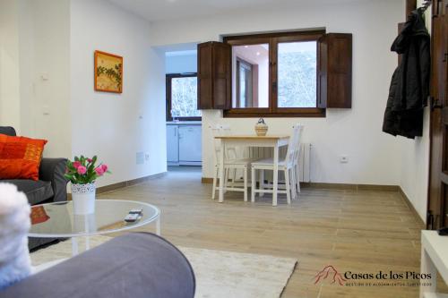 San Esteban的住宿－Apartamento rural Karibu 1 San Esteban by Casas de Los Picos Ecoturismo en los Picos de Europa，客厅配有沙发和桌子