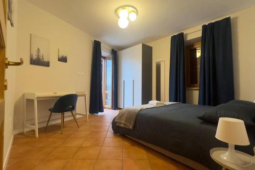 a bedroom with a bed and a desk with a chair at Fronte lago nel centro storico “La Casa del Lago” in Trevignano Romano