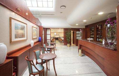 um restaurante com um bar com cadeiras e mesas em Palace Hotel em Civitanova Marche