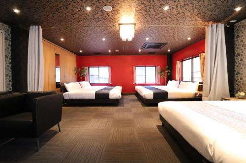 a room with three beds and a red wall at 白浜乃風 Shirahama No Kaze in Kanayama