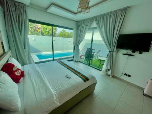 a bedroom with a bed and a large window at Les merveilles d’assinie in Assinie