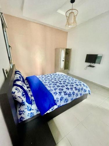a bedroom with a bed with blue and white pillows at Les merveilles d’assinie in Assinie