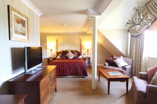 a hotel room with a bed and a tv at Grosvenor Pulford Hotel & Spa in Pulford