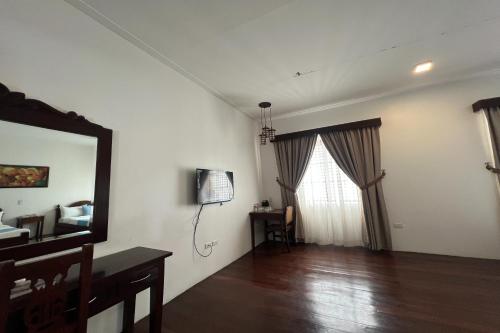 a living room with a mirror and a window at NSCC Casa De Vigan in Vigan