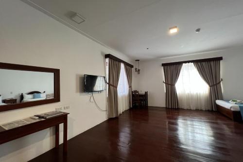 a living room with a wooden floor and a mirror at NSCC Casa De Vigan in Vigan