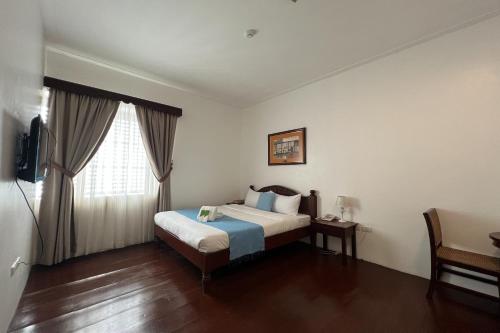 a hotel room with a bed and a window at NSCC Casa De Vigan in Vigan