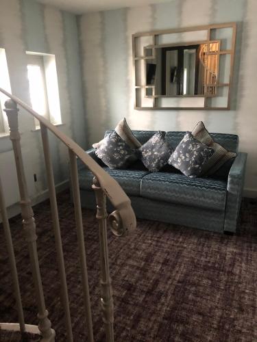a living room with a couch with pillows and a mirror at Grosvenor Pulford Hotel & Spa in Pulford